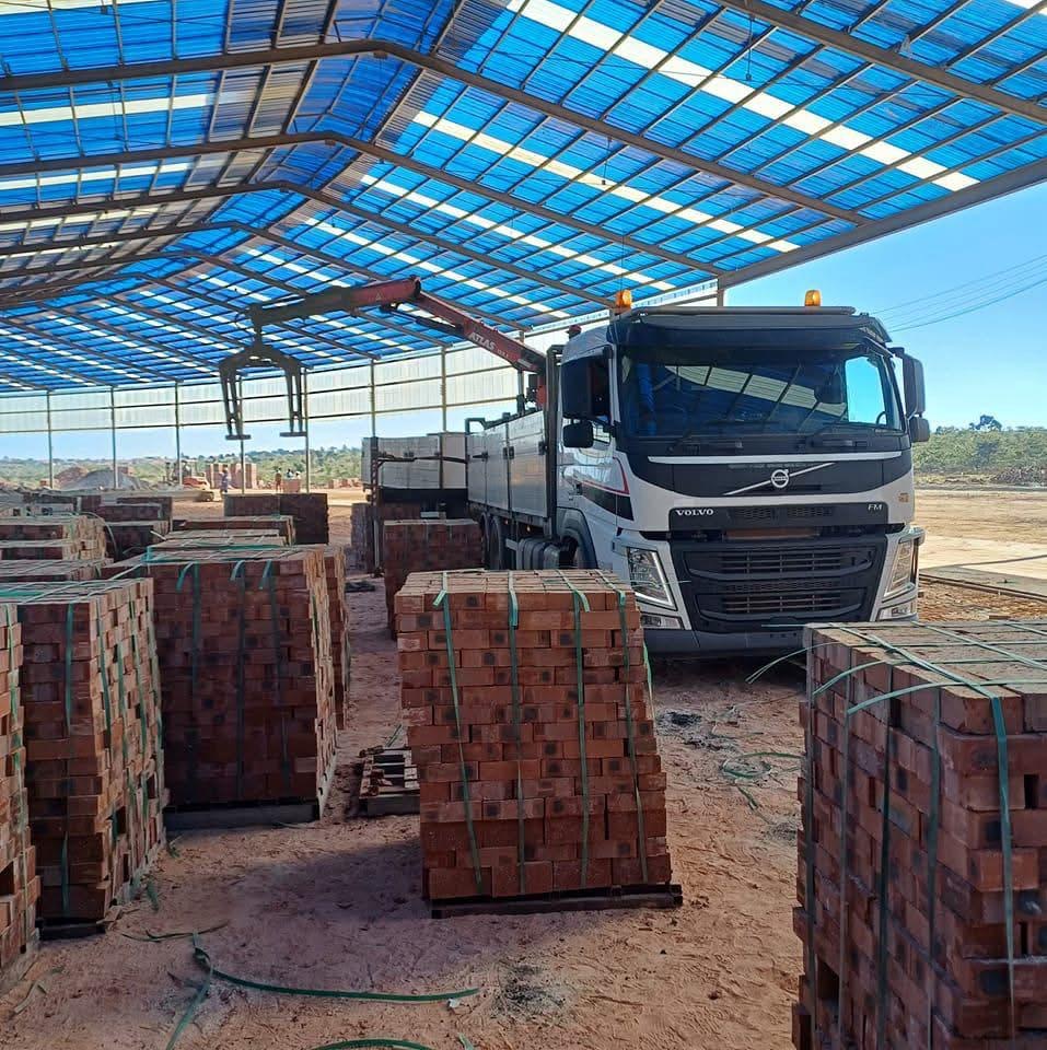Volvo FM grab truck loading bricks under a distribution centre canopy